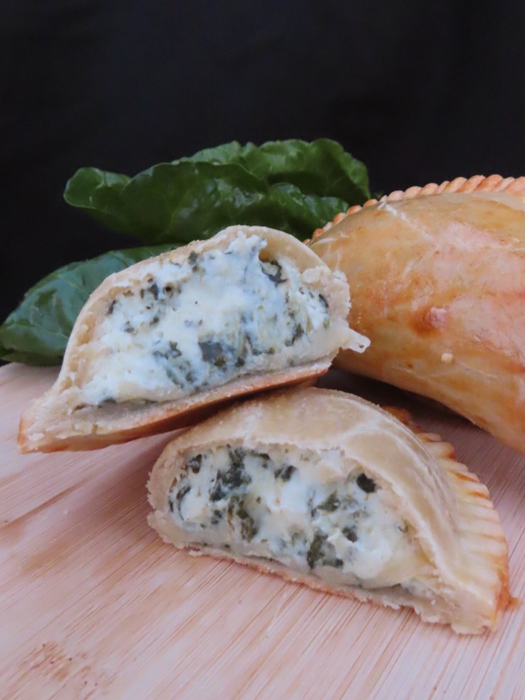 Cut empanada showing Swiss chard and cheese filling