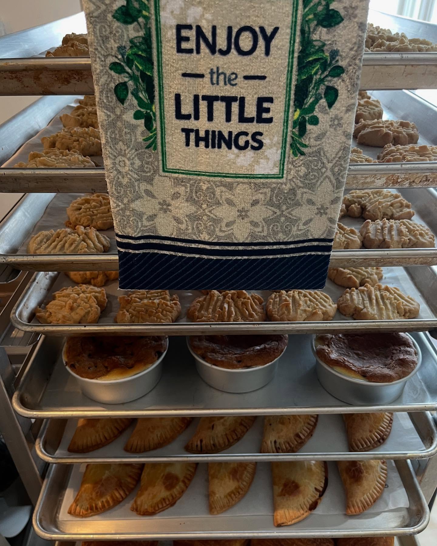 Baking rack with cookies, empanadas, and decorative sign