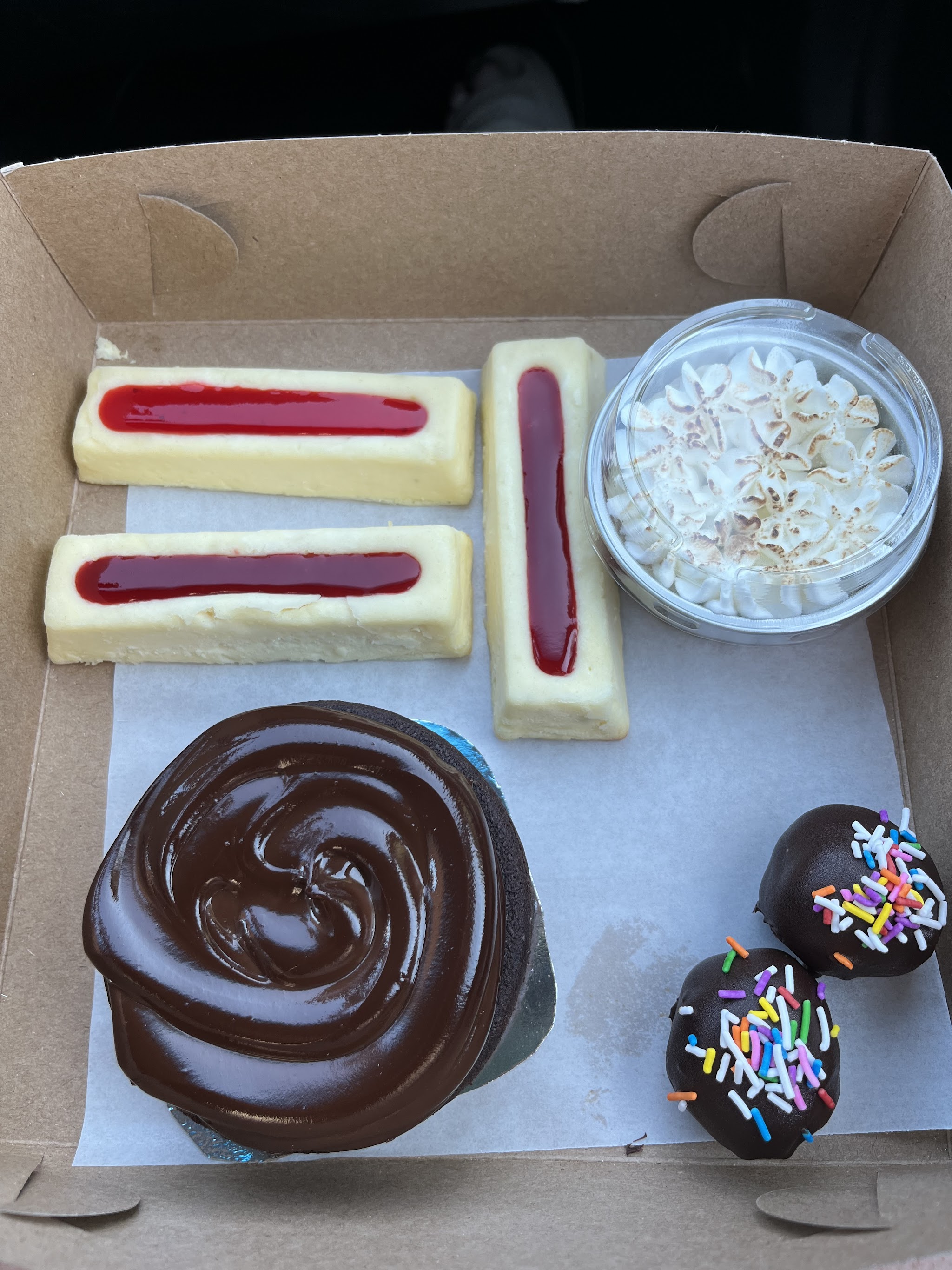 Dessert box with chocolate swirl cake, raspberry bars, and sprinkle truffles