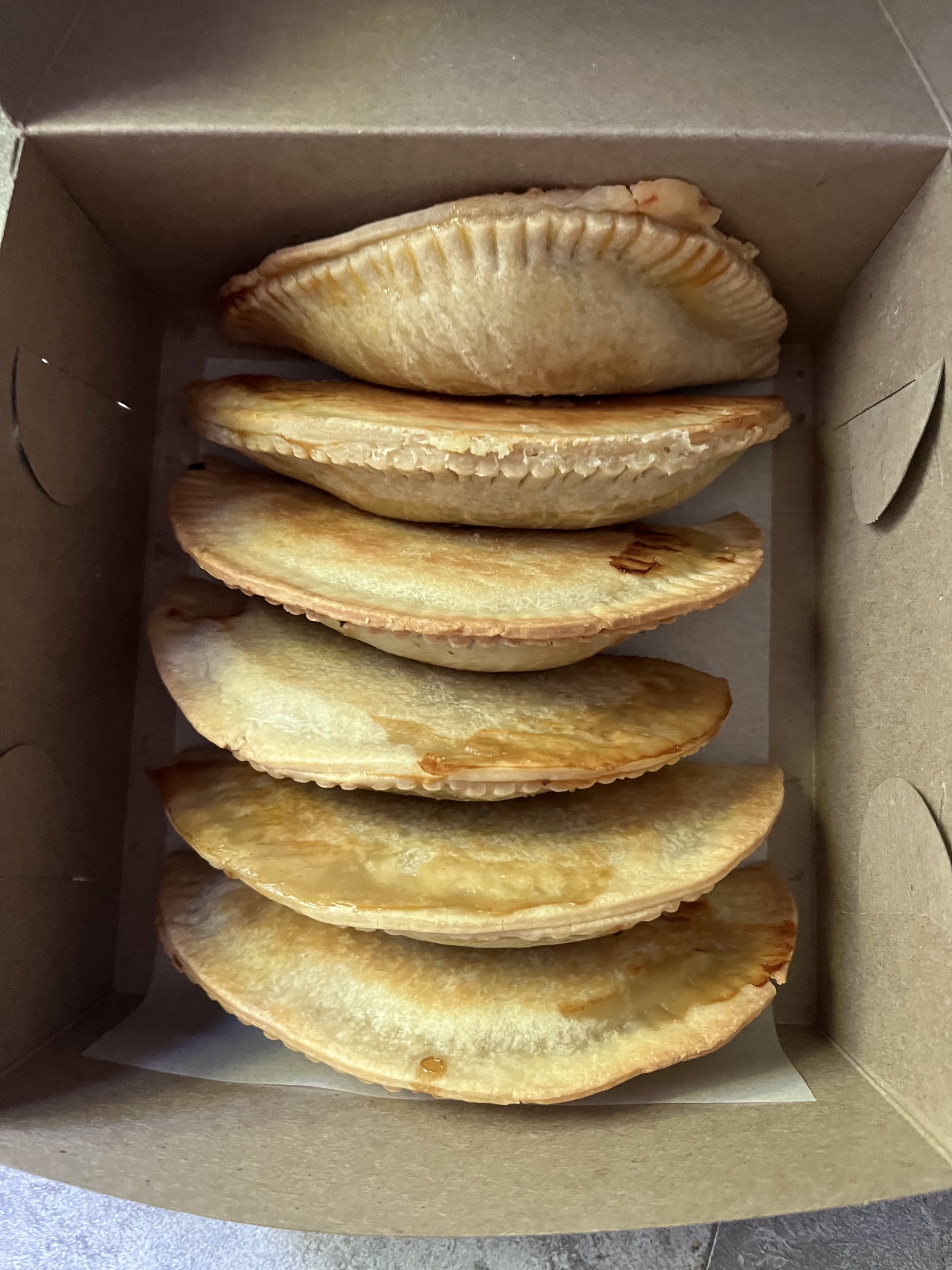 Box of freshly baked empanadas from Sainte Marie Pâtisserie